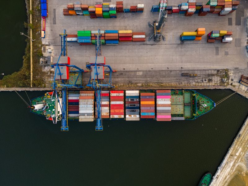 aerial view of a container ship in terminal at the port, where massive containers await their