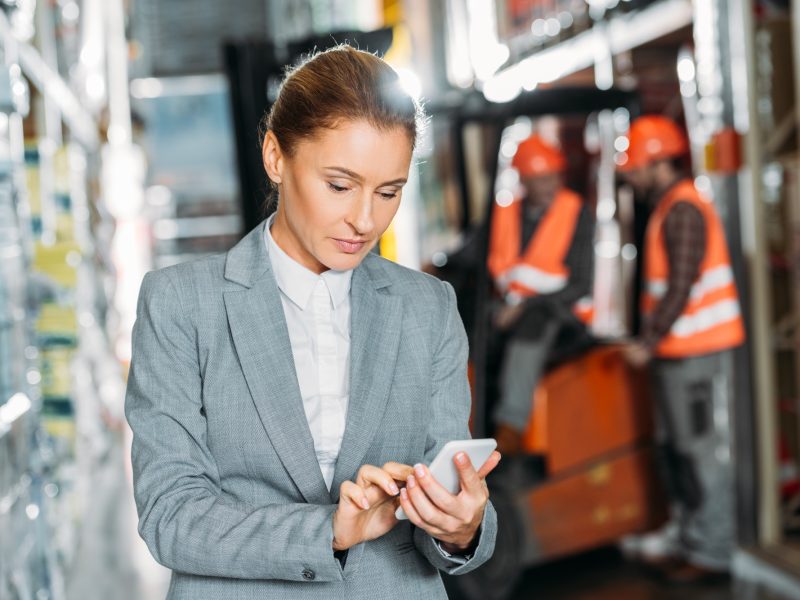 businesswoman using smartphone in shipping stock
